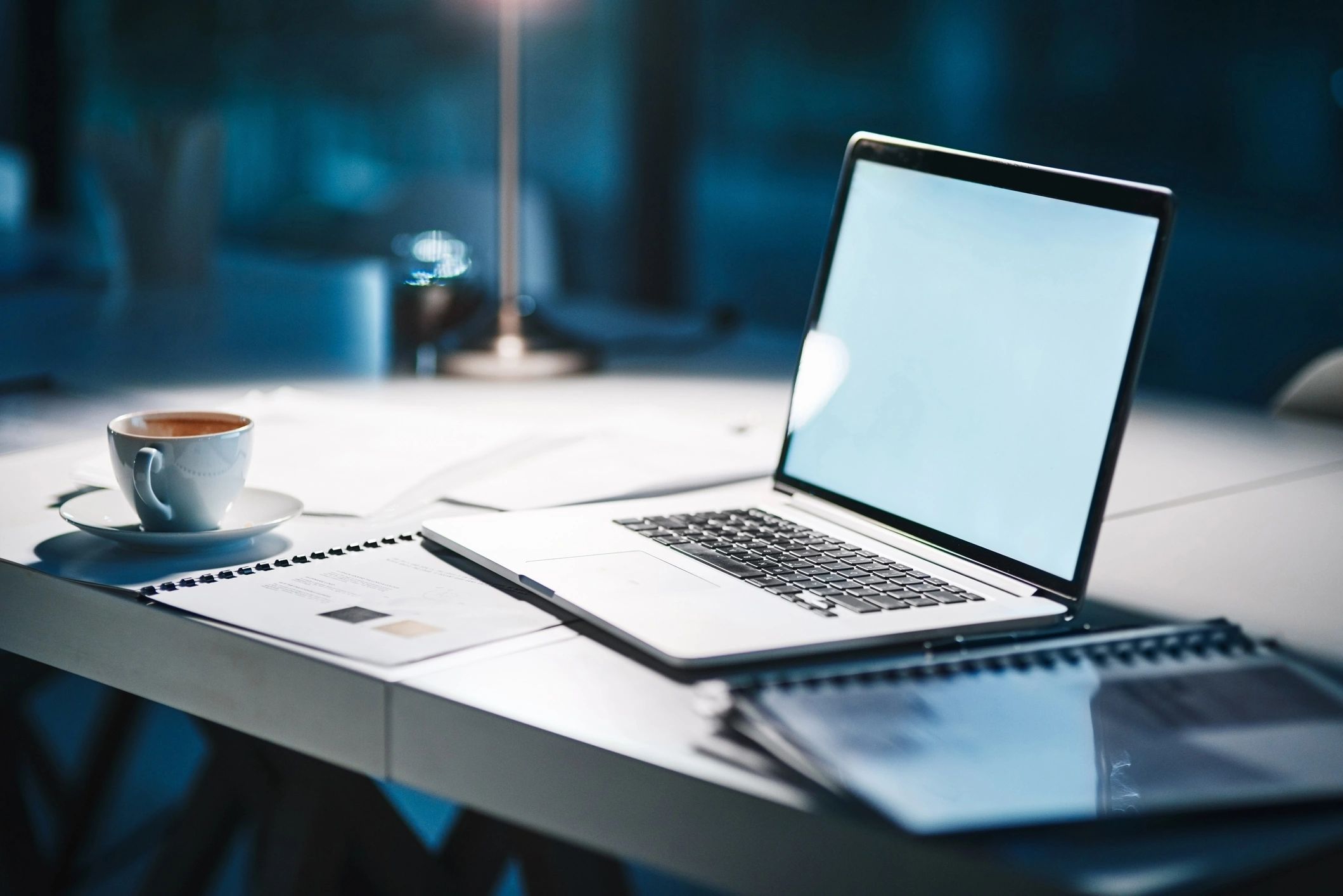 Laptop on a desk in a modern office at night with no people